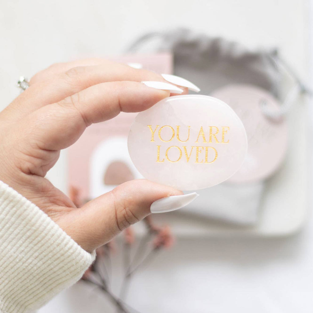 Handsten i rosenkvarts med texten 'You Are Loved'